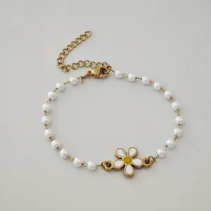 Detail shot of gold stainless steel daisy bracelet with white imitation pearls