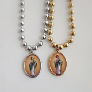 Detailweergave van Sint-Judas Thaddeus-hangers aan gouden en zilveren roestvrijstalen kogelkettingen.