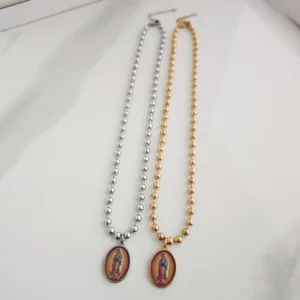 Gouden en zilveren rozenkransen van staal met 3D-geprinte Maria-hangers op marmer