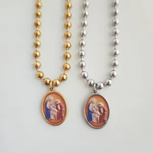 Detailweergave van gouden en zilveren rvs-kettingen met religieuze 3D-geprinte hangers