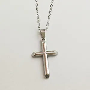 High-quality close-up of a polished stainless steel cross pendant on a matching chain necklace