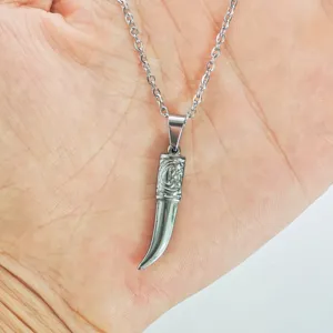 Detailed close-up of a silver stainless steel tusk-shaped pendant on a link chain