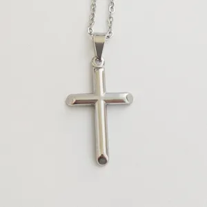 Detailed macro view of a polished silver stainless steel cross pendant on a thin chain
