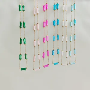 Detailed view of multiple colorful bamboo-shaped bead necklaces in various pastel shades
