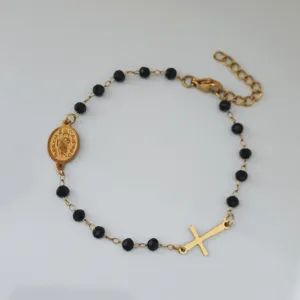Detailaufnahme eines handgefertigten vergoldeten Edelstahl-Perlenarmbands mit Kreuz