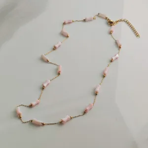 Detailed view of stainless steel necklace with pink bamboo beads and gold accents