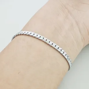 Close-up van minimalistische roestvrijstalen schakelarmband om de pols