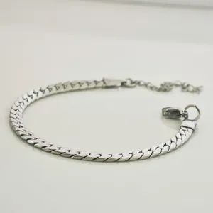 Detailopname van een zilveren roestvrijstalen Cubaanse schakelarmband op een witte achtergrond
