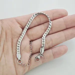 Gedetailleerd beeld van een minimalistische zilverkleurige RVS schakelarmband op hand.