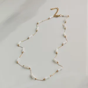 Minimalist stainless steel necklace with white bamboo-shaped beads and gold accents.