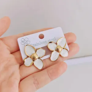 Detailed view of white enamel flower stud earrings made of durable stainless steel