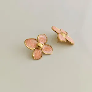 Detailed macro view of pink enamel stainless steel four-petal flower earrings