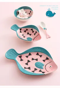 Vue macro détaillée d'assiettes et de bols en céramique peints à la main en forme de poisson