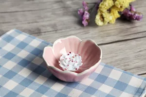 Detailed view of a pink ceramic flower-shaped incense burner with white centerpiece