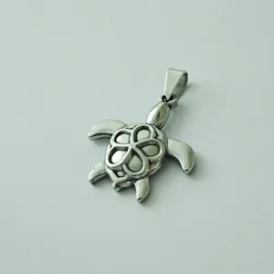 Detailed view of a stainless steel sea turtle pendant with flower pattern shell