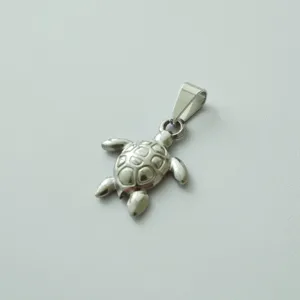 Close-up detail of a silver stainless steel sea turtle pendant with textured shell.