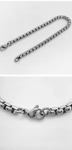 Close-up macro detail of a stainless steel box chain necklace with a secure lobster clasp