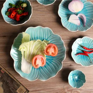 Close-up of petal-shaped light blue ceramic plates with crackle glaze on wooden table