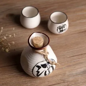 Ensemble à saké japonais en céramique avec bouteille et tasses peintes à la main.