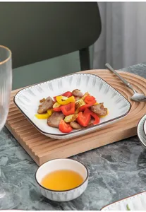 Assiette carrée en céramique avec motif à lignes, servant de la viande et du poivron.