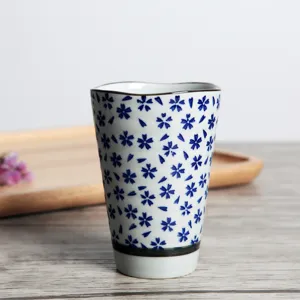 Taza de té de cerámica japonesa con patrón de flores de cerezo azul, mesa elegante