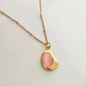 Detail view of a vintage 18K gold-plated stainless steel necklace with a pink stone