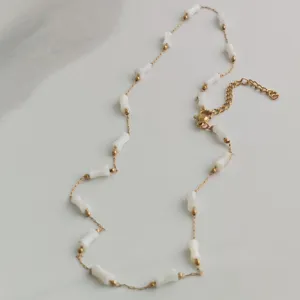 Close-up of minimalist stainless steel necklace with elegant white bamboo-shaped beads