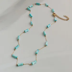 Detailed view of a minimalist stainless steel necklace with light blue bamboo beads