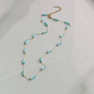 Close-up detail of light blue bamboo-shaped bead necklace with gold stainless steel chain