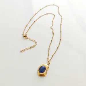 Detailed view of a vintage gold-plated necklace with an elegant blue stone pendant