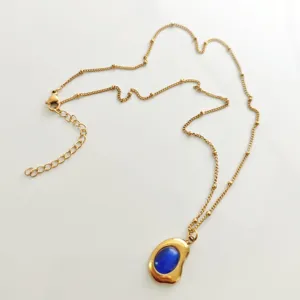Detailed view of a vintage 18K gold plated necklace featuring a striking blue stone.
