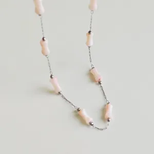Close-up of pink bamboo-joint beads on a stainless steel chain necklace