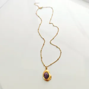 Detailed macro shot of vintage 18K gold plated necklace with purple stone pendant