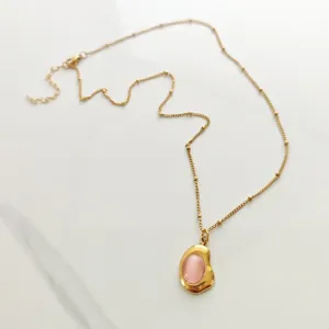Close-up of vintage 18K gold plated necklace with an elegant pink stone pendant