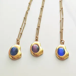 Detail showing three vintage gold-plated necklaces with colorful round gemstone pendants
