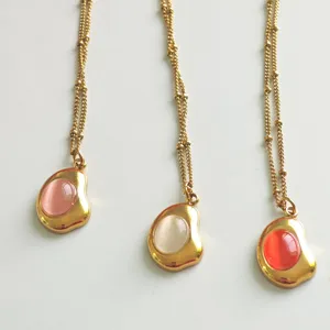 Close-up view of vintage 18K gold plated necklaces featuring colorful cat eye pendants