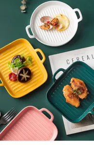 Gros plan de plats à griller nordiques colorés en céramique avec fonds rainurés et poignées.