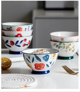 Detail view of a hand-painted Japanese ceramic bowl with vibrant floral patterns.