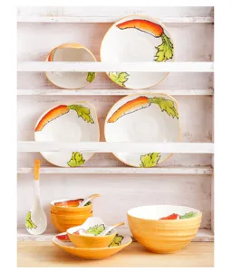 Collection de vaisselle en céramique avec motifs carottes peints à la main sur une étagère.