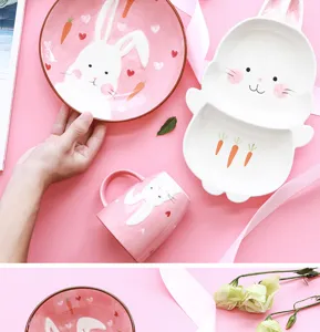 Détail d'un service de table en céramique lapin rose avec assiettes et mug pour enfant