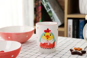 Gros plan d'un mug en céramique avec poussin peint à la main sur une nappe à carreaux