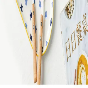 Gros plan des couverts à manche en bois sur une assiette en céramique à motifs d'étoiles.