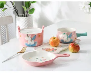 Vue détaillée du service de table en céramique rose licorne avec bols et assiettes.