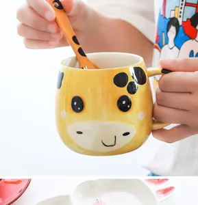 Gros plan d'un mug en céramique girafe jaune avec cuillère assortie pour enfants