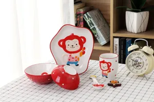 Détail d'un service de table en céramique pour enfants avec un motif de singe peint à la main