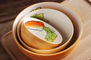 Gros plan de trois bols en céramique japonais empilés avec motif carotte peint