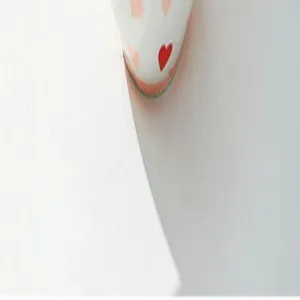 Gros plan d'un joli motif de cœur rouge sur de la vaisselle en céramique blanche fine.