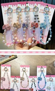 Close-up detail of multi-colored rhinestone bow and pearl beaded mobile phone lanyards