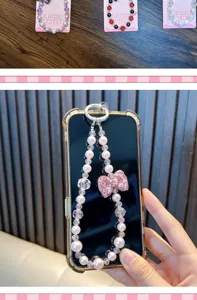 Close-up of elegant pink pearl phone strap with a sparkling rhinestone bow detail