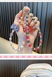 Close-up of beaded phone wristlet with shimmering rhinestone bow and crystal pearls